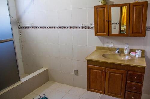 a bathroom with a sink and a shower and a tub at Pousada Lagomar em Maricá in Maricá