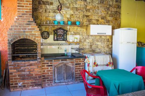 a kitchen with a brick wall with a brick oven at Pousada Lagomar em Maricá in Maricá