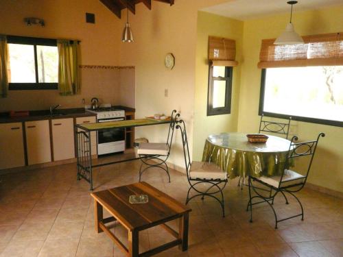 una cucina con un tavolo e sedie in una stanza di Cabañas La Lucinda a Cortaderas