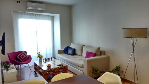 ein Wohnzimmer mit einem Sofa und einem Tisch in der Unterkunft Apartamento en Palermo, Argentina in Buenos Aires