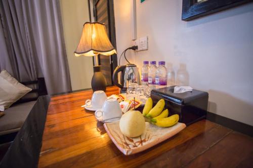 a table with bananas and a lamp on it at The Sanctuary Villa Battambang in Battambang