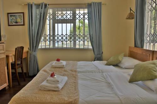 ヴィクトリアにあるBel Air Hotelのベッドルーム1室(ベッド2台、タオル付)、窓が備わります。
