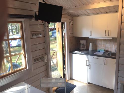 a kitchen in a tiny house with a tv on the wall at Karlstad Swecamp Bomstadbaden in Karlstad