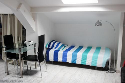 une chambre avec un lit, un bureau et une table dans l'établissement Beau Studio Nice, à Nice