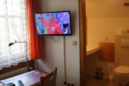 a flat screen tv hanging on a wall in a bathroom at Hotel-Restaurant Johanneshof in Nentershausen