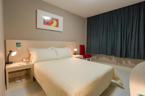 a hotel room with a large white bed and a window at Jinjiang Inn Beijing Olympics Park in Beijing