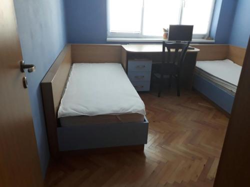 a small room with a bed and a desk with a computer at Apartment ILIEVI in Pleven