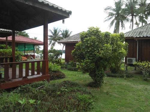 a garden with a house and a tree at Happy Days Resort in Ko Mak
