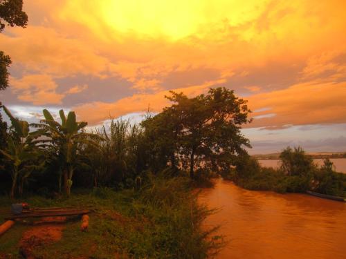a view of a river with a sunset in the background at Don Som Riverside Guesthouse in Don Som