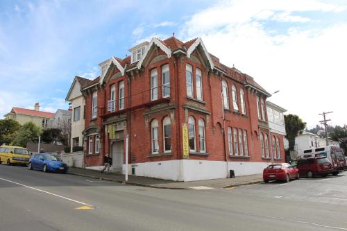 un edificio di mattoni rossi sul lato di una strada di Chalet Backpackers a Dunedin