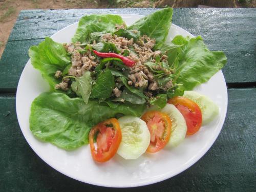 a plate of salad with lettuce and tomatoes on a table at Don Som Riverside Guesthouse in Don Som