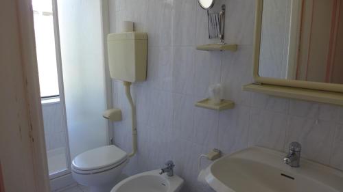 een witte badkamer met een toilet en een wastafel bij Bed and Breakfast Gioiello in Celle Ligure
