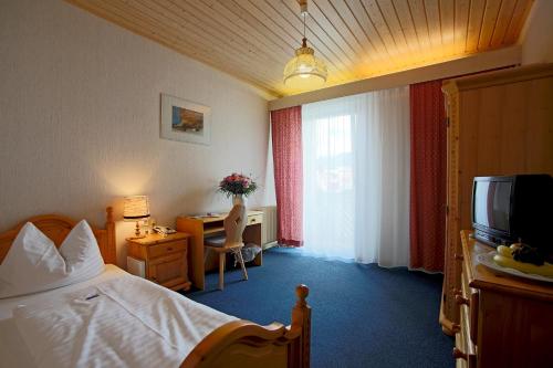 a hotel room with a bed and a television at AKTIVHOTEL Weisser Hirsch in Mariazell