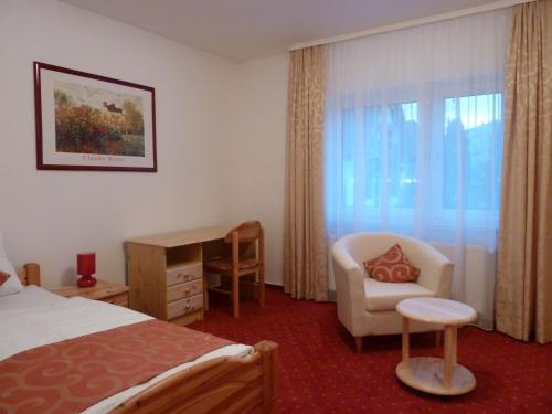 a hotel room with a bed and a chair and a desk at Landhaus Stümpelstal in Marburg an der Lahn