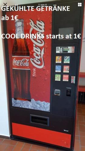 a coca cola machine with a sign on it at P63 City Rooms Nürnberg Center in Nürnberg