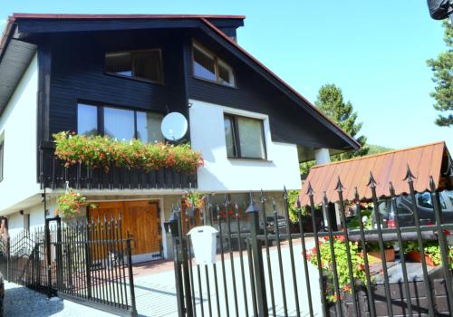 a black fence in front of a house with flowers at Willa Ewa in Szczyrk