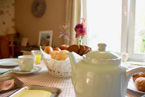 un tavolo con bollitore per il tè e un cesto di prodotti da forno di De Hagendoorn a Moorveld