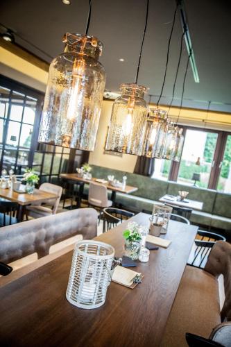 a dining room with a table and chairs and chandeliers at Hotel Stümpelstal in Marburg an der Lahn