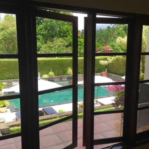 a view of a pool through a window at Bukit Asri Lodge in Seraya