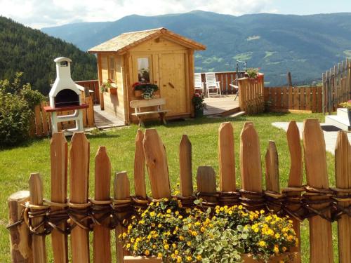a wooden fence with a small house in a yard at Bärntalerhof in Falzes