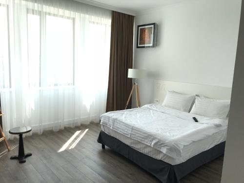 1 dormitorio con cama y ventana grande en GIA Suites, en Caracal