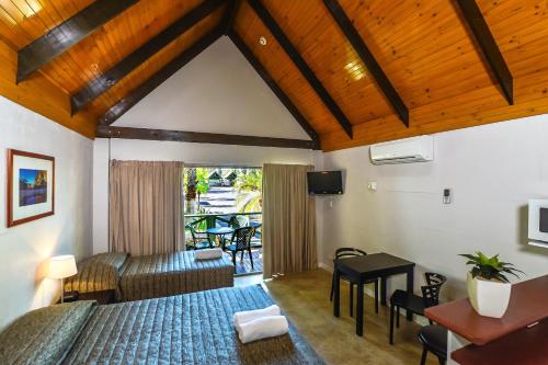 Alice Springs的住宿－沙漠棕櫚艾麗斯斯普林斯汽車旅館，一间卧室配有一张床、一张桌子和一张桌子