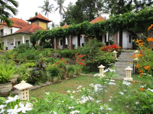 a garden in front of a house with flowers at Bukit Asri Lodge in Seraya