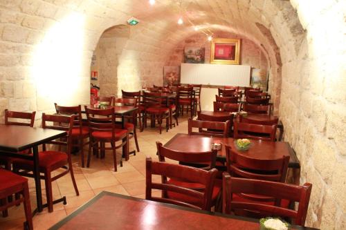 a restaurant with wooden tables and chairs in a room at Little Hôtel in Paris