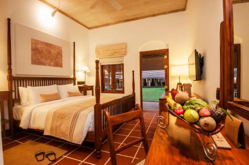 a bedroom with a bed and a bowl of fruit at EKHO Sigiriya in Sigiriya