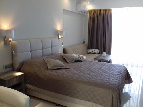 a bedroom with a large bed and a window at AKRON Luxury Holidays in Ancient Epidavros