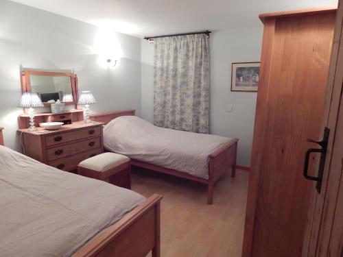1 dormitorio con 2 camas, tocador y espejo en Garden Bank Cottage, en Kelso