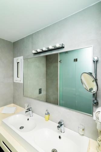 a bathroom with a sink and a mirror at Kastro Hotel in Heraklio Town