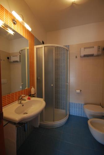 ein Badezimmer mit Dusche, Waschbecken und Toilette in der Unterkunft Residence Helene in Tortoreto Lido