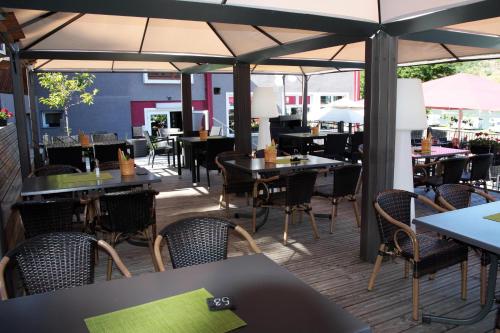 un ristorante con tavoli, sedie e ombrelloni di Winzerhaus Gärtner - An der Loreley a Sankt Goar