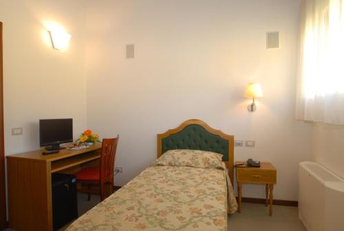 a bedroom with a bed and a desk with a computer at Villa Aretusi in Bologna