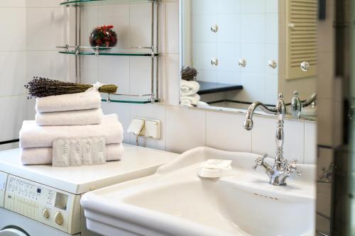 y baño con lavabo, espejo y toallas. en LuxApartments - Басманный тупик, en Moscú