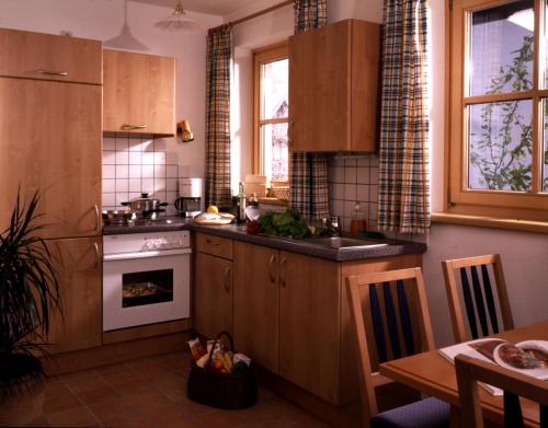 a kitchen with wooden cabinets and a stove top oven at Ferienwohnungen Sport Löb in Maria Alm am Steinernen Meer
