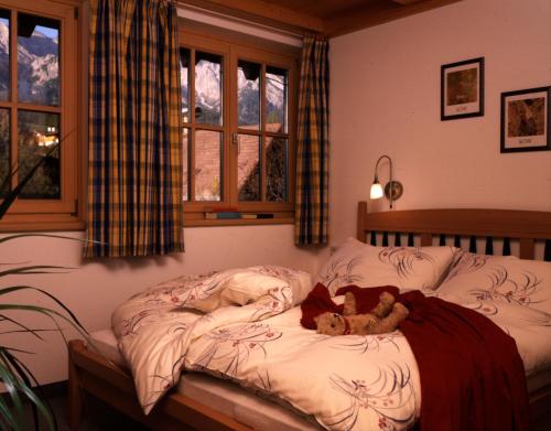 a teddy bear laying on a bed in a bedroom at Ferienwohnungen Sport Löb in Maria Alm am Steinernen Meer