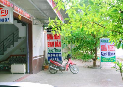 a motorcycle parked in front of a building with signs at Thanh Thúy Guesthouse in Ðông Hà