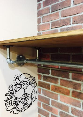 a shelf on a brick wall with a doodle on it at Bear Hotel in Sanxia