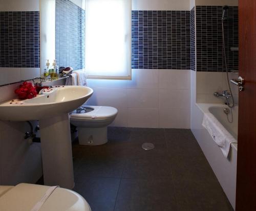 uma casa de banho com um lavatório, um WC e uma banheira em Aparthotel Diamant Blue em Playas de Orihuela