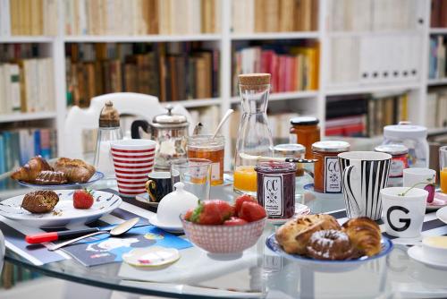 a table with plates of food on it with books at Queen Christine in Villeneuve d'Ascq