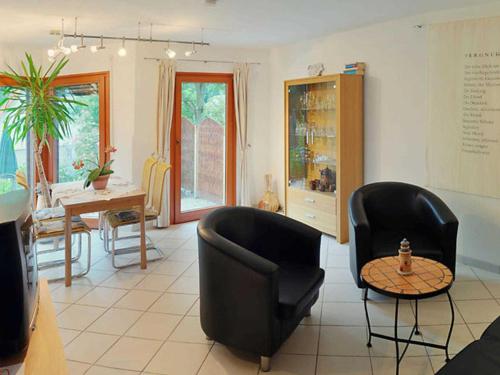 ein Wohnzimmer mit zwei schwarzen Stühlen und einem Tisch in der Unterkunft Ferienwohnungen Zum Anker _ Objekt in Diedrichshagen