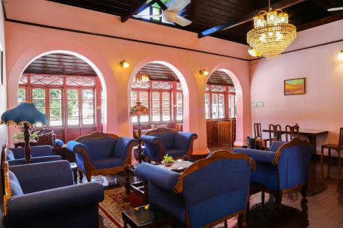 a lobby with blue chairs and a chandelier at Chiramel Residency in Cochin