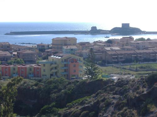 a group of houses on a hill next to the ocean at Hotel Isola Rossa in Bosa