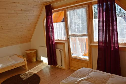 a bedroom with a bed and two windows at "kleines jagdhaus"- Hüttenurlaub in Bayern in Philippsreut