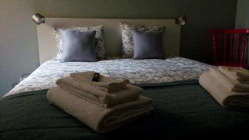 a bedroom with a bed with towels on it at Lost in Terceira in Angra do Heroísmo