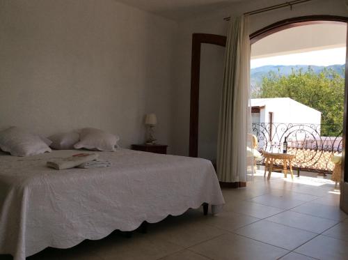 um quarto com uma cama e vista para uma varanda em La Ramada em Cafayate