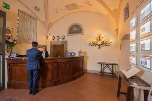 a man in a suit standing at a counter at Hotel San Michele in Cortona