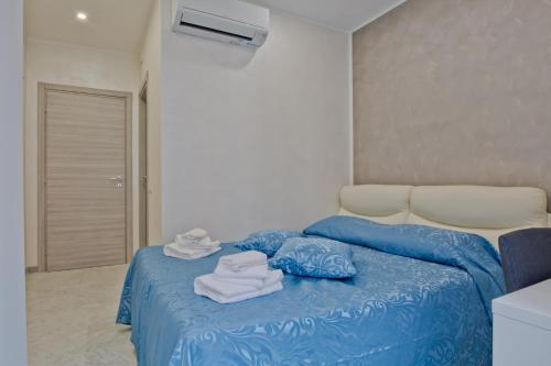 Un dormitorio con una cama azul con toallas. en Oscar 2, en Roma